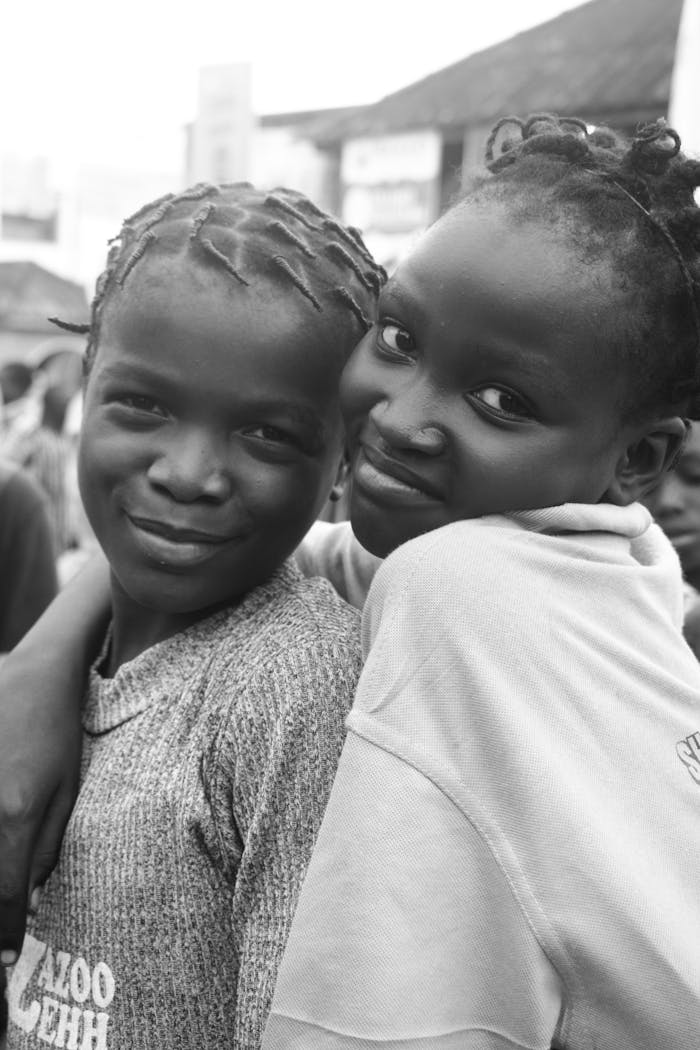 Smiling African girls posing happily together, showcasing their close friendship.